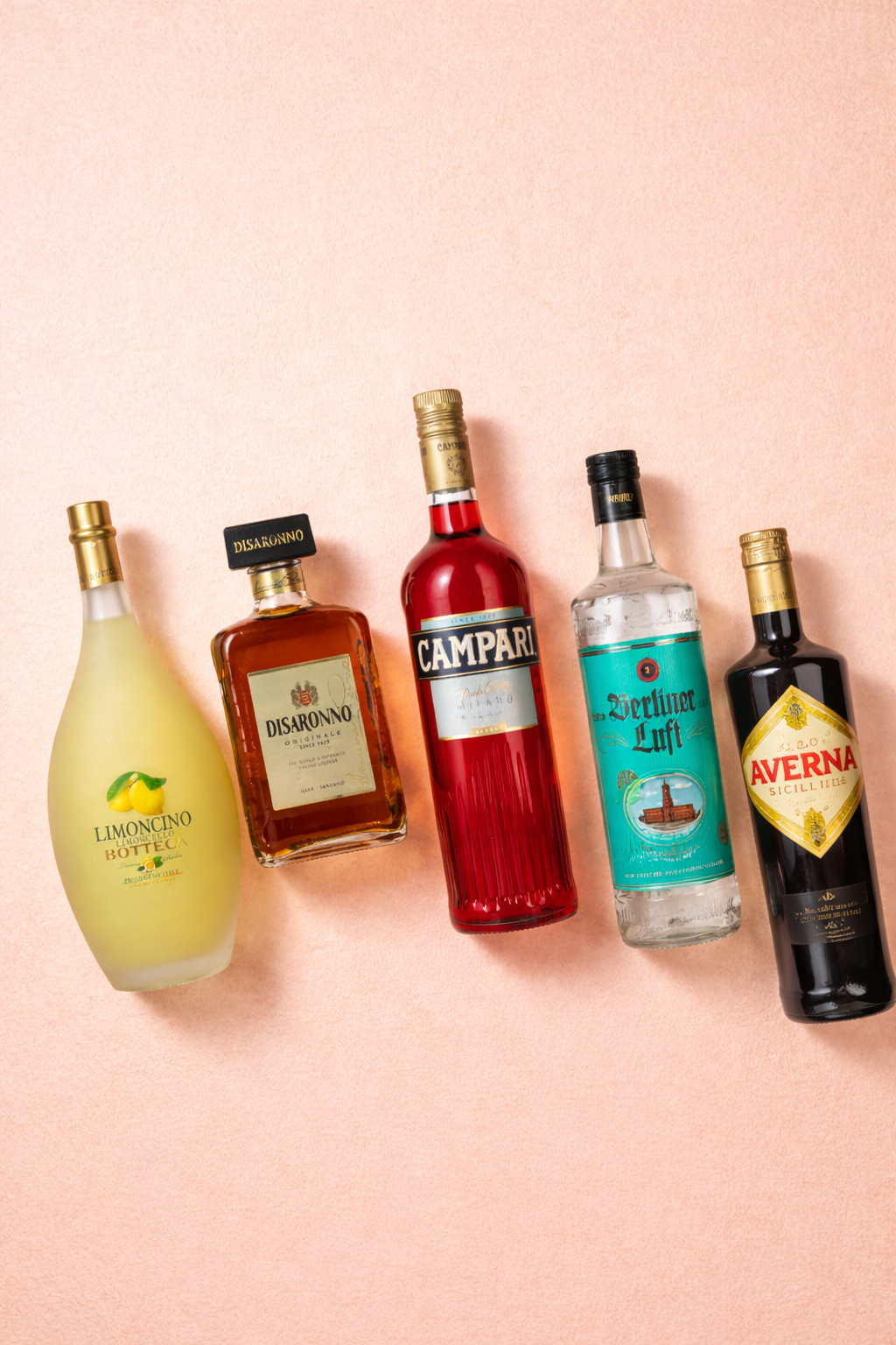 Fünf Aperitif- und Likörflaschen auf rosafarbenem Hintergrund.